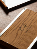 Underside of a cont. serving tray in oak wood with an engraved cont. logo and stainless-steel frame