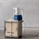 Petrol-blue Studio.LUNA L001 lamp switched off, standing on a Studio.LUNA wooden crate